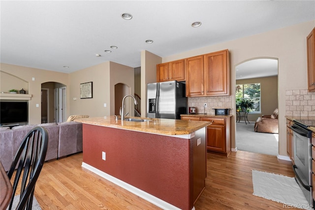 16896 E Maplewood Dr, Aurora, CO 80016 - kitchen with appliances with stainless steel finishes, open floor plan, light wood-style floors, arched walkways, and recessed lighting