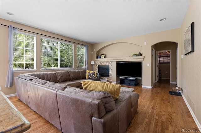 16896 E Maplewood Dr, Aurora, CO 80016 - living room featuring arched walkways, light wood-style flooring, and a glass covered fireplace