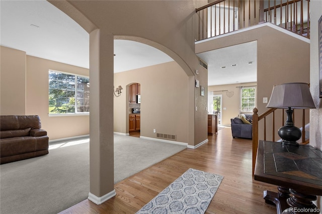 16896 E Maplewood Dr, Aurora, CO 80016 - living area with arched walkways, wood finished floors, and carpet flooring