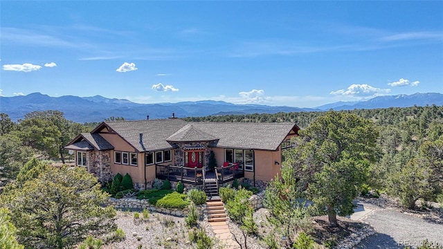 12850 County Road 261k, Nathrop, CO 81236 - view of front of house featuring a deck with mountain view, stone siding, and stairway