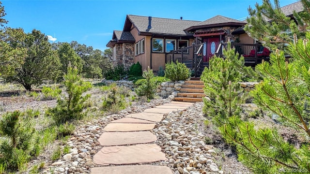 12850 County Road 261k, Nathrop, CO 81236 - view of front of house featuring stone siding, stairway, stucco siding, roof with shingles, and a wooden deck