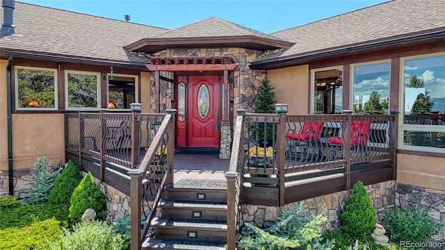 12850 County Road 261k, Nathrop, CO 81236 - entrance to property featuring a shingled roof, stone siding, a deck, and stucco siding