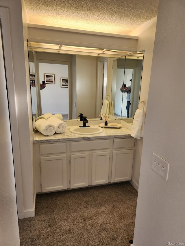 bathroom featuring vanity, baseboards, and a textured ceiling