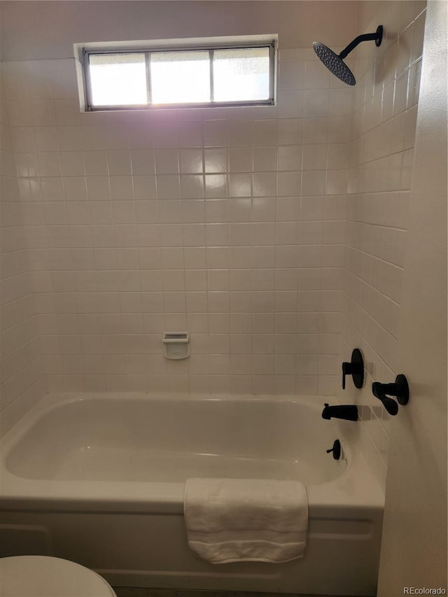 bathroom featuring toilet, tub / shower combination, and a wealth of natural light