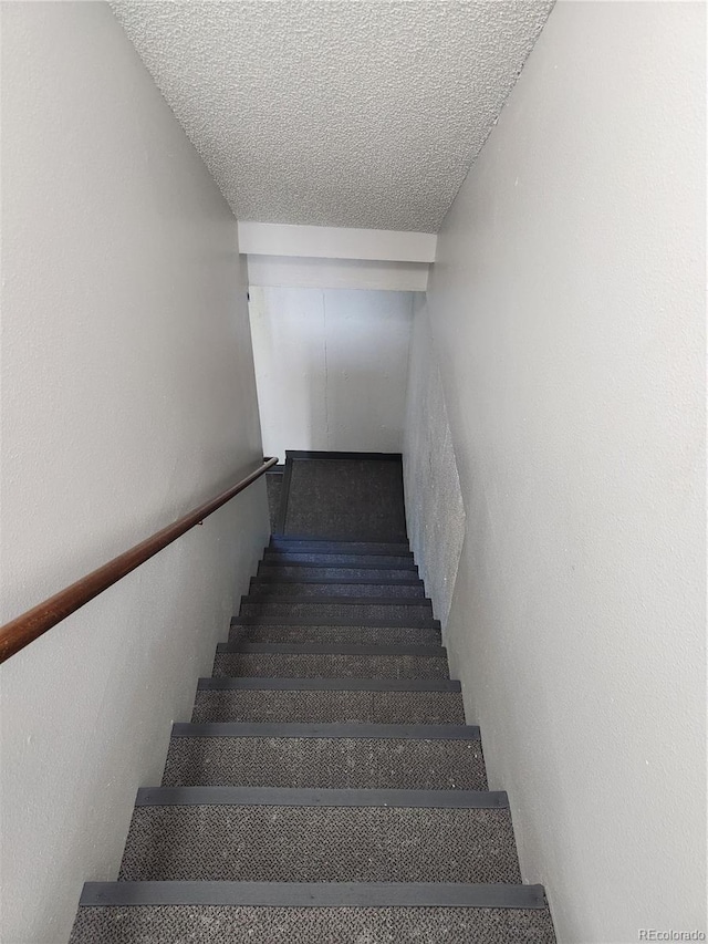 staircase with a textured ceiling