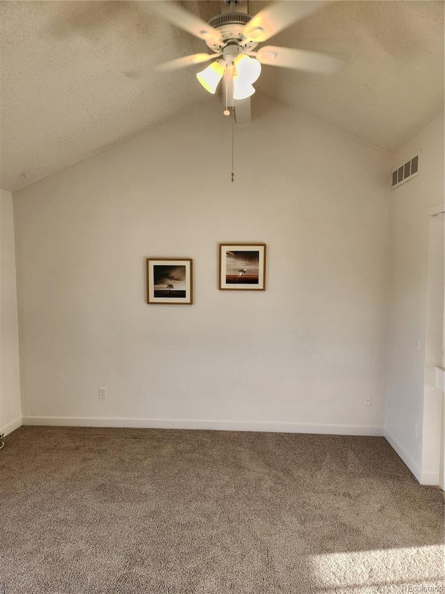 spare room with vaulted ceiling, carpet flooring, visible vents, and ceiling fan