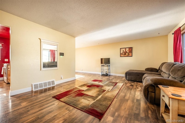 living room featuring dark hardwood / wood-style flooring and a textured ceiling