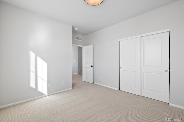 unfurnished bedroom featuring a closet and light carpet