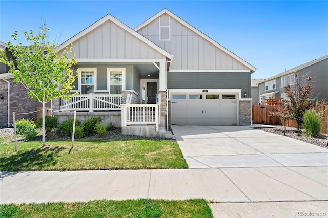 872 S Flat Rock Way, Aurora, CO 80018 - view of front of home with board and batten siding, a garage, a porch, concrete driveway, and stone siding
