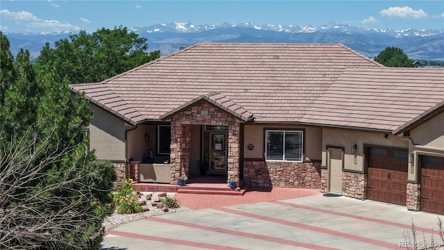 1246 Highland Pl, Erie, CO 80516 - view of front of home with stone siding, stucco siding, a garage, concrete driveway, and a mountain view