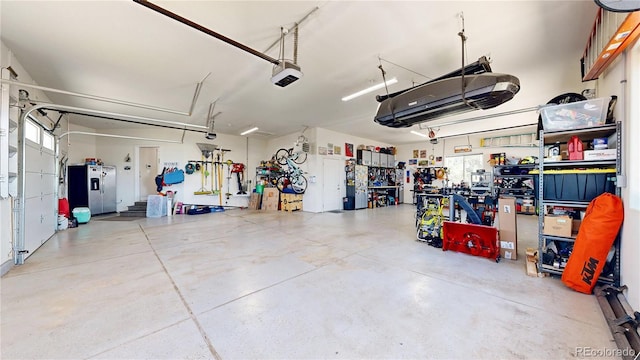 1246 Highland Pl, Erie, CO 80516 - garage with a garage door opener, stainless steel refrigerator with ice dispenser, and a workshop area