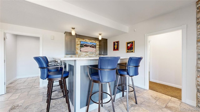 1246 Highland Pl, Erie, CO 80516 - kitchen featuring stone tile floors, a kitchen breakfast bar, and light countertops