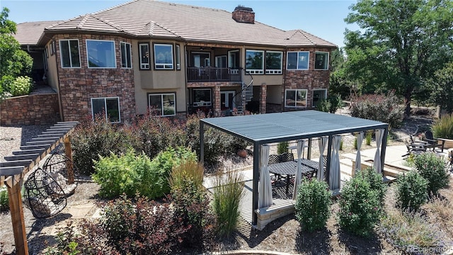 1246 Highland Pl, Erie, CO 80516 - back of property with stone siding, a chimney, stucco siding, and stairway