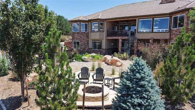1246 Highland Pl, Erie, CO 80516 - back of property with a fire pit, stucco siding, stone siding, and stairway