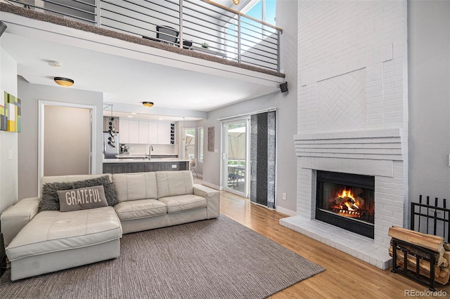 9673 Pinebrook St, Highlands Ranch, CO 80130 - living room with light wood finished floors, a fireplace, a high ceiling, and baseboards