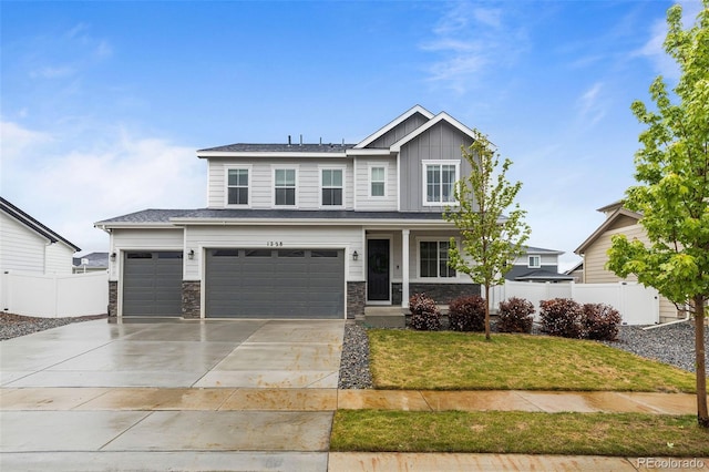 1228 Argali Dr, Severance, CO 80550 - view of front of home featuring board and batten siding, a porch, driveway, a garage, and stone siding