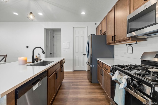 1228 Argali Dr, Severance, CO 80550 - kitchen featuring stainless steel appliances, a sink, dark wood finished floors, brown cabinetry, and recessed lighting
