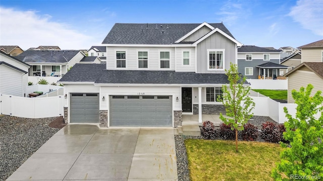 1228 Argali Dr, Severance, CO 80550 - view of front of property featuring board and batten siding, stone siding, driveway, a shingled roof, and a garage