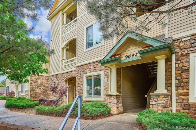 9692 W Coco Cir Unit 103, Littleton, CO 80128 - view of exterior entry with stone siding and a balcony