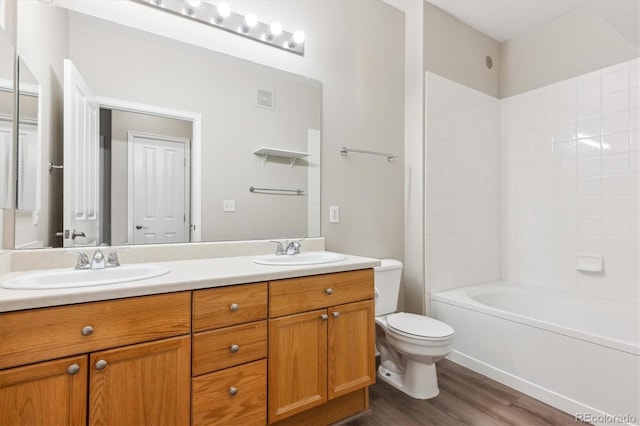 9692 W Coco Cir Unit 103, Littleton, CO 80128 - full bath with double vanity, toilet, wood finished floors, and bathing tub / shower combination