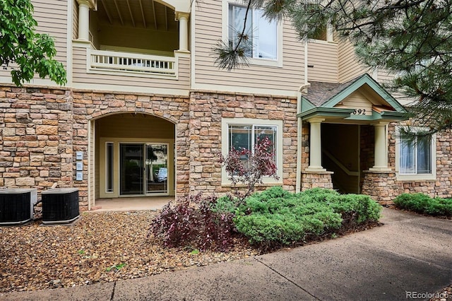 9692 W Coco Cir Unit 103, Littleton, CO 80128 - entrance to property with stone siding, central AC, and a balcony