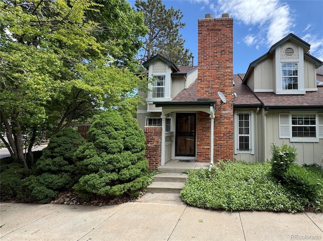 971 S Evanston Cir, Aurora, CO 80012 - view of front of house with a chimney, a shingled roof, and board and batten siding