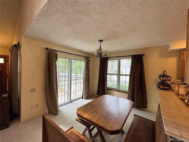 971 S Evanston Cir, Aurora, CO 80012 - dining area featuring a chandelier, light carpet, and a textured ceiling