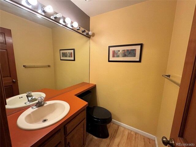 971 S Evanston Cir, Aurora, CO 80012 - half bath with wood finished floors, vanity, toilet, and baseboards