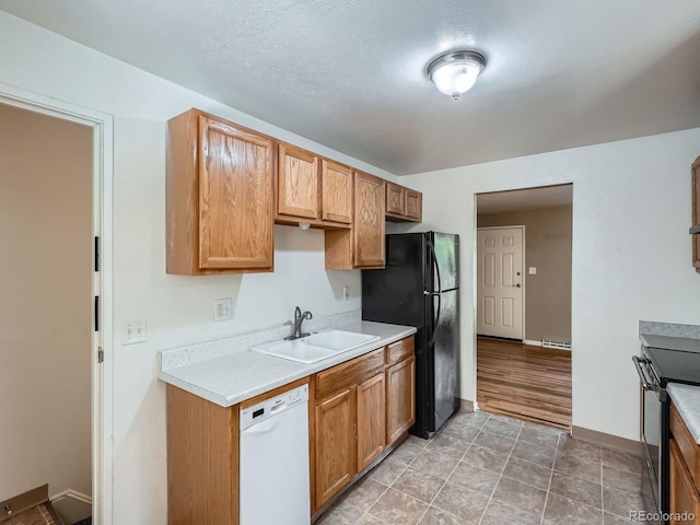 1455 S Zephyr St, Lakewood, CO 80232 - kitchen with dishwasher, freestanding refrigerator, light countertops, electric stove, and baseboard heating