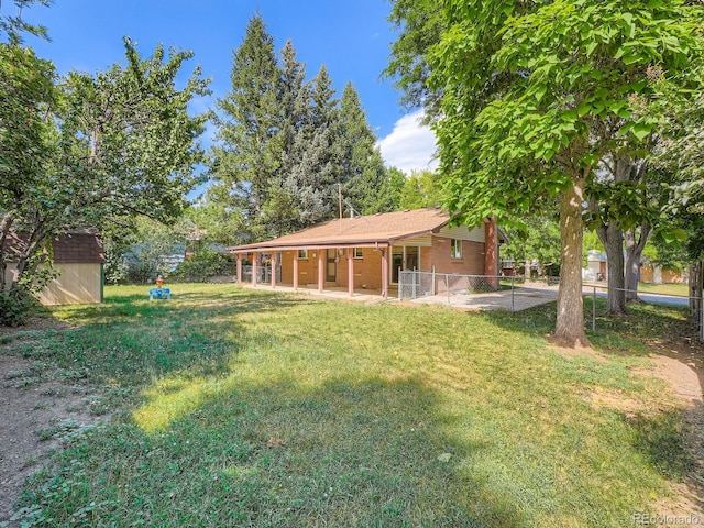 1455 S Zephyr St, Lakewood, CO 80232 - back of property with a storage shed and a patio area