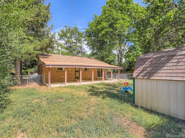 1455 S Zephyr St, Lakewood, CO 80232 - rear view of property with a patio area, a fenced backyard, a storage shed, and brick siding