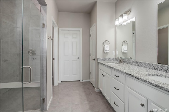 6330 Lythmore Grv, Colorado Springs, CO 80927 - full bath with a stall shower, tile patterned flooring, double vanity, and baseboards