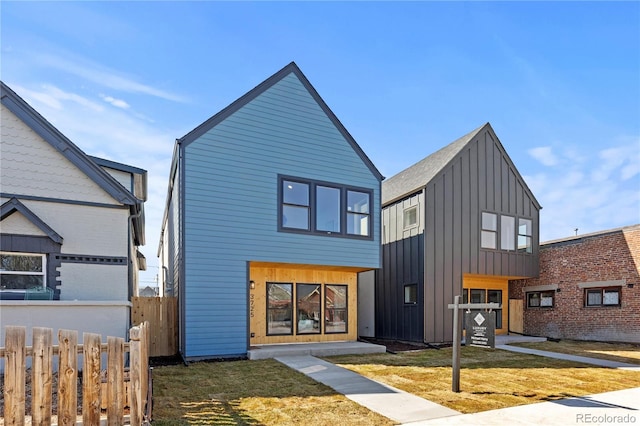 view of front facade featuring fence, a front lawn, and board and batten siding