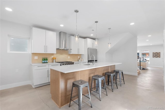3725 N Franklin St, Denver, CO 80205 - kitchen with a breakfast bar area, a center island with sink, wall chimney exhaust hood, white cabinets, and concrete floors
