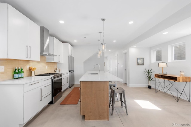 3725 N Franklin St, Denver, CO 80205 - kitchen featuring a sink, decorative backsplash, wall chimney exhaust hood, a center island with sink, and appliances with stainless steel finishes