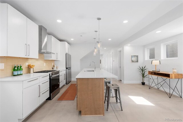 3725 N Franklin St, Denver, CO 80205 - kitchen with wall chimney exhaust hood, appliances with stainless steel finishes, an island with sink, backsplash, and a breakfast bar area