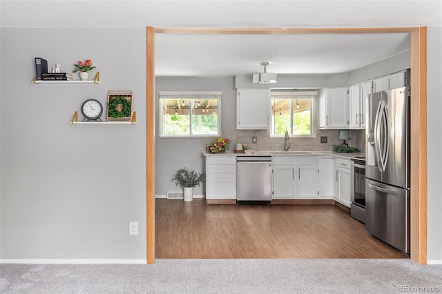 6353 W 78th Ave, Arvada, CO 80003 - kitchen with stainless steel appliances, white cabinetry, light countertops, and decorative backsplash
