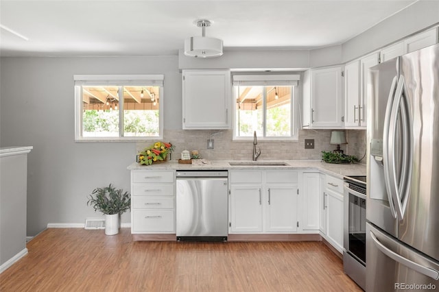 6353 W 78th Ave, Arvada, CO 80003 - kitchen with appliances with stainless steel finishes, light wood-style flooring, and white cabinets