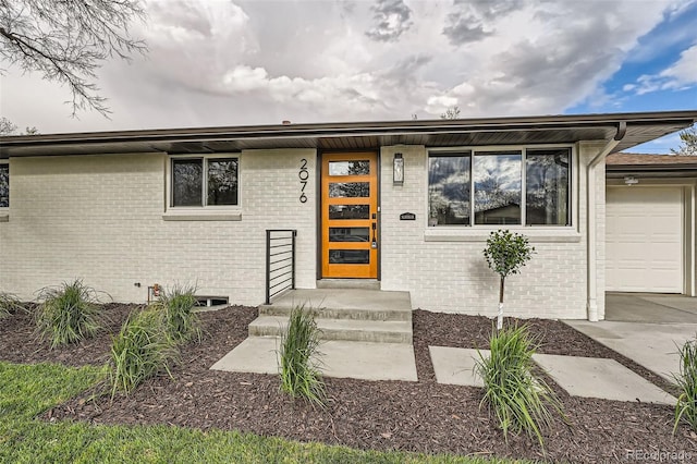 view of front of house featuring brick siding, an attached garage, and driveway