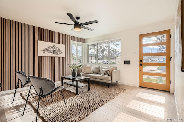 living room with baseboards, plenty of natural light, ceiling fan, and wood finished floors