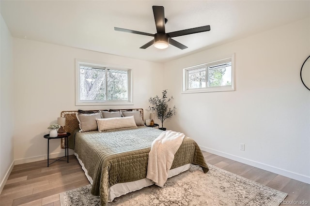 bedroom featuring baseboards, ceiling fan, and light wood-type flooring