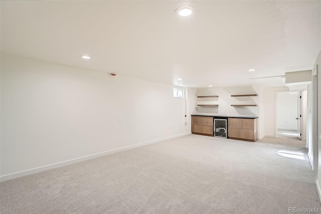 interior space with wine cooler, baseboards, light carpet, and a bar