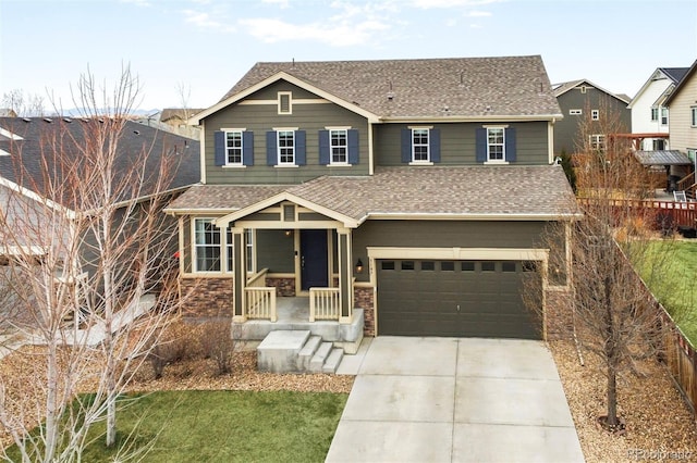 craftsman house featuring fence, an attached garage, driveway, and roof with shingles