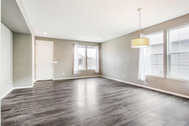 spare room featuring recessed lighting, baseboards, and dark wood-style floors