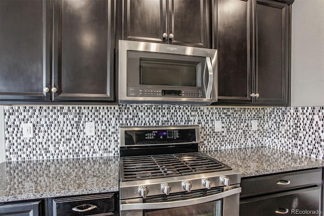 kitchen featuring backsplash, stainless steel appliances, light stone countertops, and dark brown cabinets