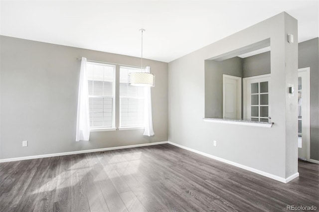 unfurnished room with baseboards and dark wood-type flooring
