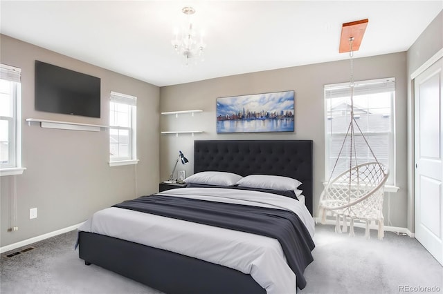 carpeted bedroom with visible vents, baseboards, and a notable chandelier