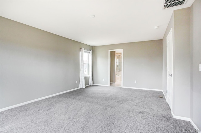 spare room featuring carpet floors, baseboards, and visible vents