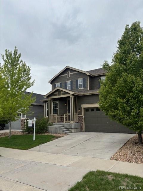 3197 Raintree Ln, Dacono, CO 80514 - view of front of home featuring a garage, concrete driveway, covered porch, and a front yard