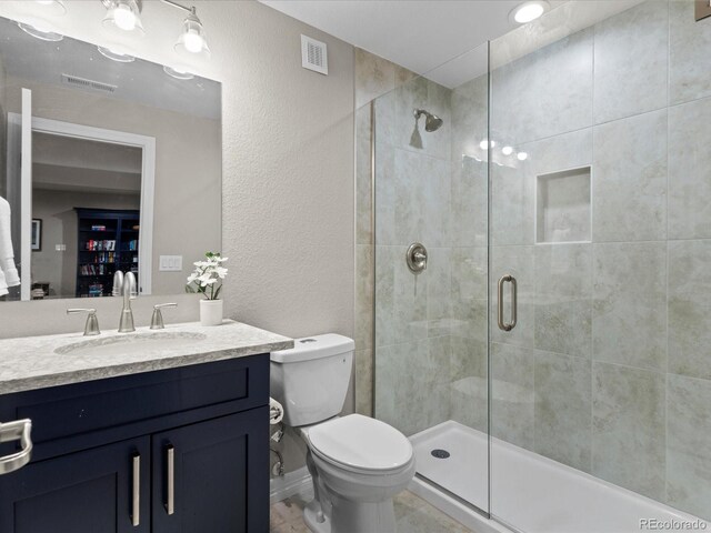 5439 Verbena St, Denver, CO 80238 - full bathroom with toilet, vanity, a stall shower, and a textured wall